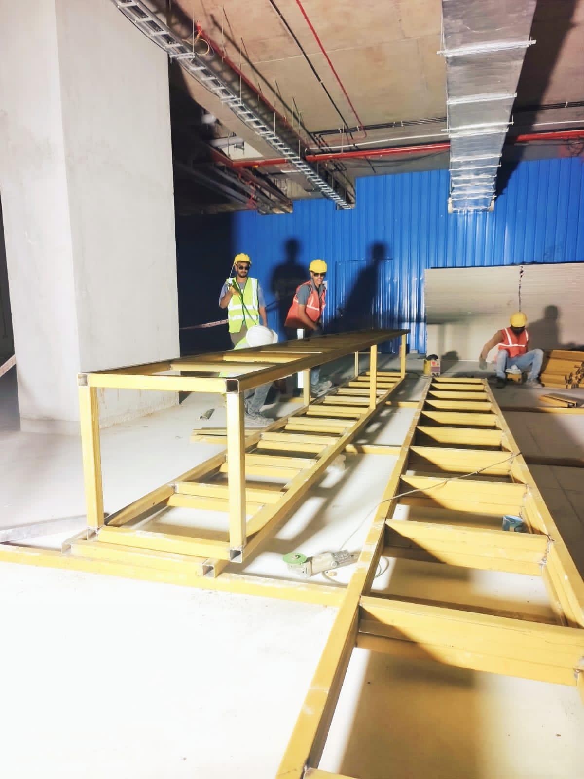 Long metal planter framework being assembled on site